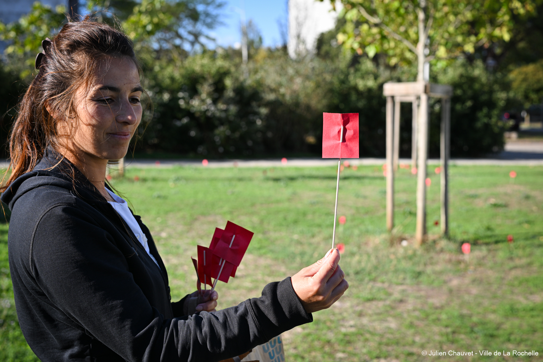 Julie Pacteau tenant un coquelicot rouge lors de l'Opération Coquelicot
